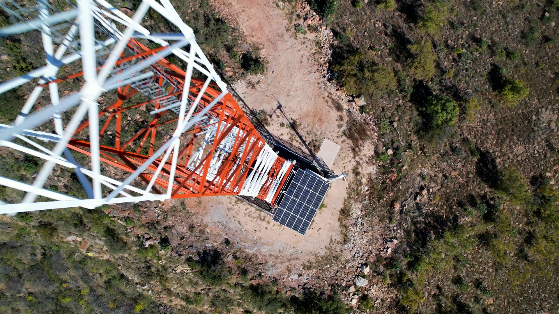 Top-down drone view of a tower base with solar panels in the South African bushveld